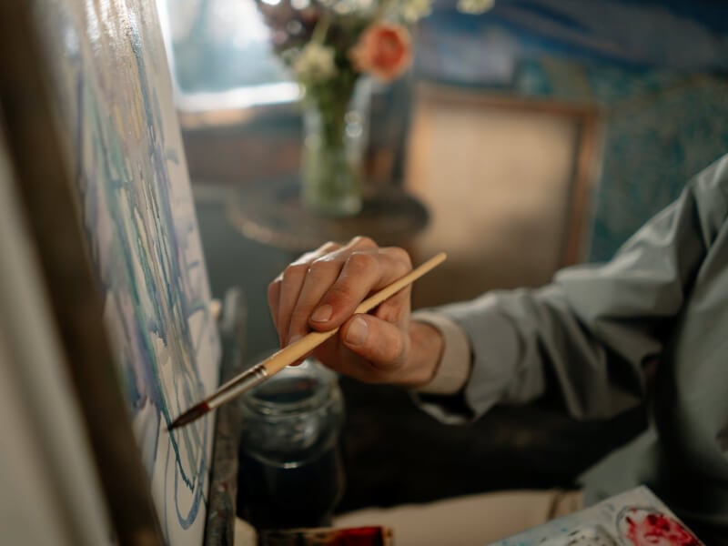 A man painting on a paint canvas